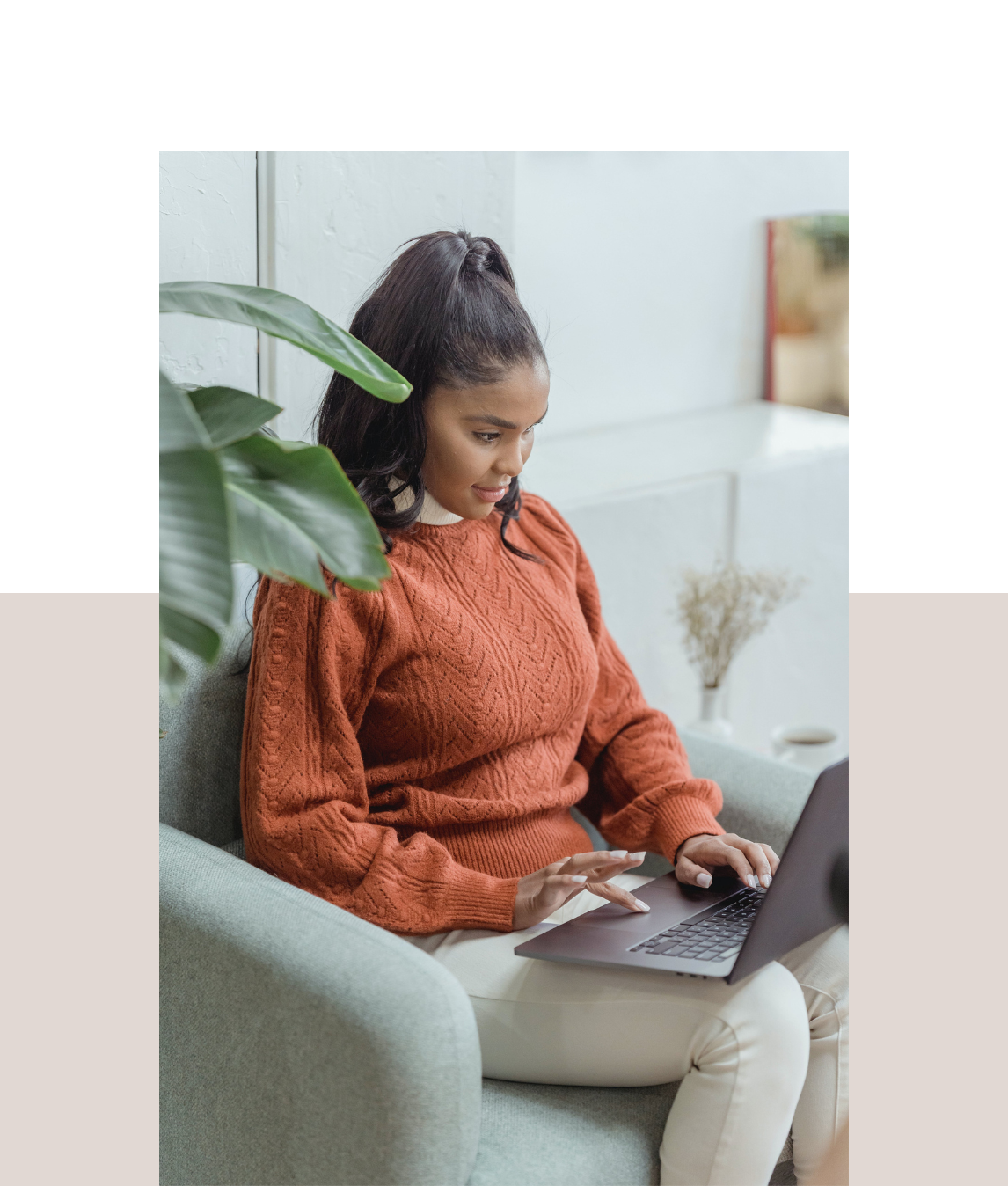 Woman engaged in work on her laptop, surrounded by a warm and stylish living room atmosphere.