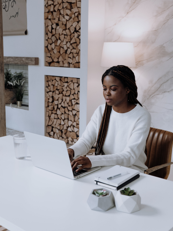 pretty woman sitting at her desk in her office working on the laptop
