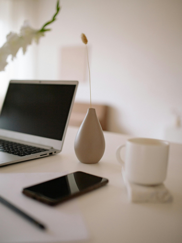 desk with laptop vase and cell phone