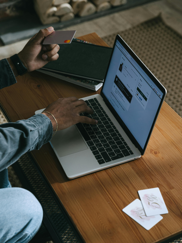 man sitting at desk shopping online with his credit card